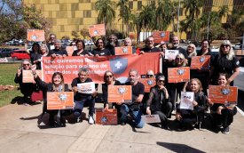 Imagem mostra aposentados do Itaú segurando cartazes em frente antes da audiência pública para debater os valores das mensalidades do plano de saúde dos ex-funcionários do banco