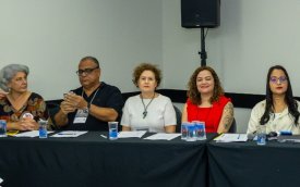 Imagem mostra cinco dirigentes sentados lado a lado em uma mesa