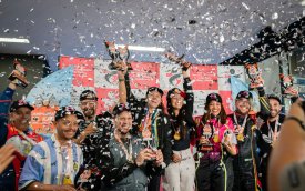 Fotografia mostra corredores do Kart com troféus nas mãos em chuva de confete 