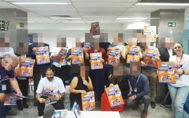 Imagem mostra bancários e dirigentes posando lado a lado  empunhando cartazes onde se lê  "Saúde Caixa reajuste zero"
