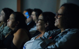 Rosto de pessoas em tela escura durante cinema 