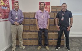 Imagem mostra três dirigentes sindicais em frente a dezenas de cestas básicas