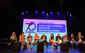 Imagem mostra representantes das centrais sindicais, sentados lado a lado em um palco, durante seminário do dieese. atrás deles há um painel onde se lê 70 anos Dieese. Seminário internacional. Disputar a renda, reduzir desigualdades