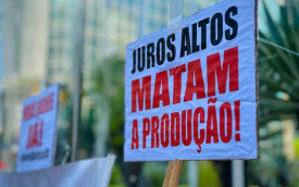 Imagem do ato contra a taxa selic, relizado pleos trabalhadores, mostra placa onde se lê "juros altos matam a  população"