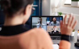 Imagem de uma mulher em frente a um computador, em uma reunião virtual