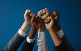 Imagem de punhos cerrados erguidos, em fundo azul