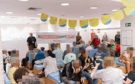 Imagem mostra dirigente do sindicato estendendo faixa onde se lê "os trabalhadores exigem respeito" dentro de uma agência superlotada do Banco do Brasil