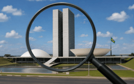Imagem mostra uma lupa sobre o prédio do congresso nacional