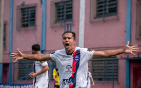 Jogador comemora um gol com os braços abertos