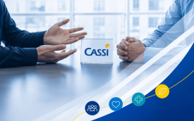 Imagem composta de uma foto que mostra mãos de duas pessoas frente a frente em uma mesa de negociação. entre eles e sobre a mesa há uma placa com o logo da Cassi. No canto inferior direito há ícones remetendo à saúde, como um coração e uma cruz