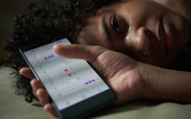 Imagem de uma mulher chorando e segurando um celular