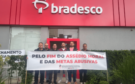 Foto de dirigentes sindicais em frente a agência do Bradesco segurando uma faixa contra assédio moral