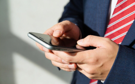 Imagem mostra homem mexendo em um telefone celular