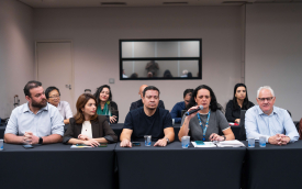 Foto dos representantes dos empregos da Caixa na mesa de negociação com o banco desta quarta (19); ao microfone, a diretora do Sindicato, Luiza Hansen