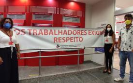 Dirigentes sindicais em frente a uma agência protestam contra a direção do Santander com uma faixa "Os trabalhadores exigem respeito"