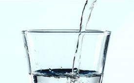 Imagem mostra um copo de vidro transparente sendo servido com água