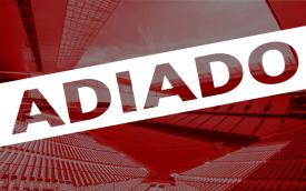 Arte com a foto do estádio vazio do Corinthians ao fundo, sob um filtro vermelho, sobreposto a palavra "adiado"