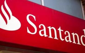 Fachada de agência do Santander, focada na placa com o logo e com o nome do banco