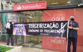 Dirigentes sindicais em frente a uma agência do Santander paralisada em protesto contra a reestruturação promovida pelo banco. Eles seguram uma faixa onde se lê: "Tercerização é sinônimo de precarização"