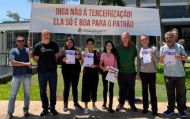 Dirigentes protestam contra terceirização no Santander. Eles estão em frente a uma faixa onde se lê: "Diga não à terceirização. Ela só é boa para o patrão."