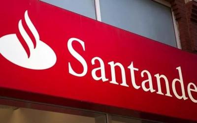 Imagem mostra fachada de agência do Santander, focada na placa onde se vê o nome e o logo do banco
