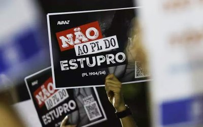 Imagem de protesto contra o PL1904. A imagem mostra braços erguidos portando cartazez onde se lê "Não ao PL do estupro"