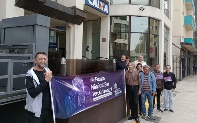 Dirigentes do Sindicato seguram faixa da Campanha em frente a uma agência da Caixa