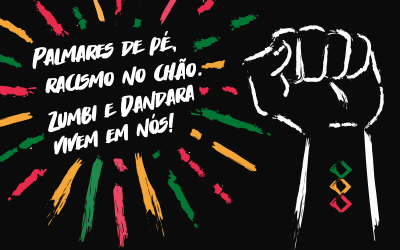 Ilustração de um punho erguido, em fundo preto, com a frase "Palmares de pé, racismo no chão. Zumbi e Dandara vivem em nós" ao lado