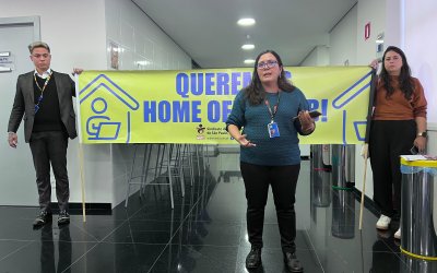 Fotografia mostra tres pessoas segurando faixa pedindo respeito ao Banco do Brasil