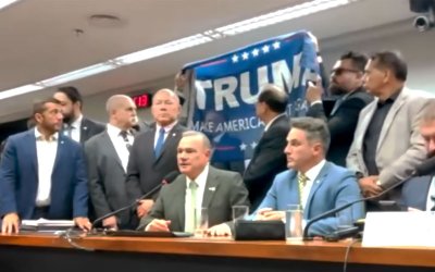 Foto mostra deputados federais levantando bandeira de Trump