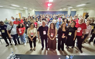 Fotografia mostra várias pessoas em pé durante encontro dos funcionários do Bradesco