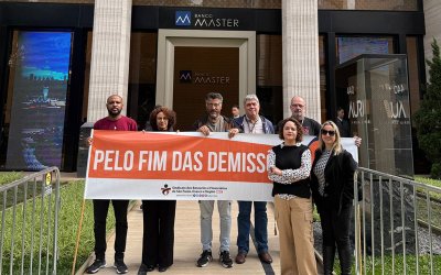 Em frente à sede do Master, dirigentes do Sindicato seguram faixa em que reivindicam o fim das demissões no banco