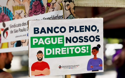 Foto de placa do ato em que se lê: "Banco Pleno pague nossos direitos"