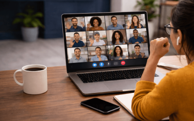 Imagem mostra mulher de costas, em frente a um notebook, participando de uma reunião virtual. a tela do computador projeta vários rostos de pessoas entusiasmadas