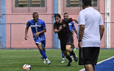Jogador de futebol disputando a bola com adversários