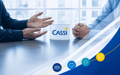 Imagem composta de uma foto que mostra mãos de duas pessoas frente a frente em uma mesa de negociação. entre eles e sobre a mesa há uma placa com o logo da Cassi. No canto inferior direito há ícones remetendo à saúde, como um coração e uma cruz