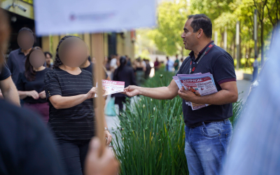 Imagem mostra dirigente sindical welington correa distribuindo material impresso a bancários do santander