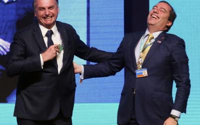 Bolsonaro e Pedro Guimarães apertam as mãos rindo