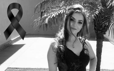 Foto em preto e branco de Karina Alves Vasconcelos, ao lado de um laço negro