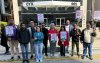 Dirigentes sindicais posam com cartazes de protesto em frente ao Bank of China