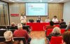 Imagem mostra auditório cheio durante encontro estadual dos bancários do Santander; na frente, a secretária-geral do Sindicato Lucimara Malaquias fala  ao microfone, em pé. Atrás dela, estão sentados em uma mesa Wanessa de Queiroz, Ana Lúcia Ramos e Ana Marta Lima, respectivamente coordenadora da COE Santander; secretária-geral da Fetec-CUT/SP; e diretora executiva do sindicato