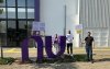 Imagem mostra dirigentes em frente ao prédio do Nubank. Eles seguram placas 