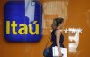 Fachada do Itaú com uma mulher loirando passando em frente