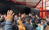Foto da assembleia, com mãos levantadas em aprovação ao acordo