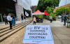 Imagem mostra protesto em frente ao BV em respostas às demissões. A imagem destaca em primeiro plano uma placa onde se lê "negociação coletiva Já"