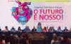 Imagem mostra dirigentes lado a lado no palco do 7º Congresso Nacional da Contraf-CUT. Atrás deles há um telão imenso com uma arte formada por um coração estilizado ao lado do texto "O Futuro é Nosso"