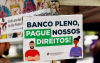 Foto de placa do ato em que se lê: "Banco Pleno pague nossos direitos"