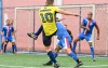 Jogador vestindo a camiseta do Equador chutando uma bola contra 3 adversários de azul