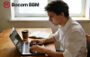 Imagem mostra um homem jovem, branco e de cabelos curtos trabalhando em um computador