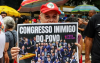 Imagem mostra mulher segurando um cartaz onde se lê "congresso inimigo do povo"